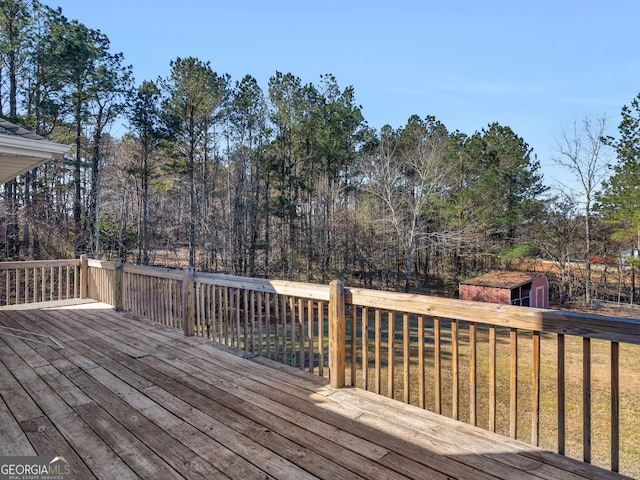 wooden terrace featuring a yard, a storage unit, and an outdoor structure