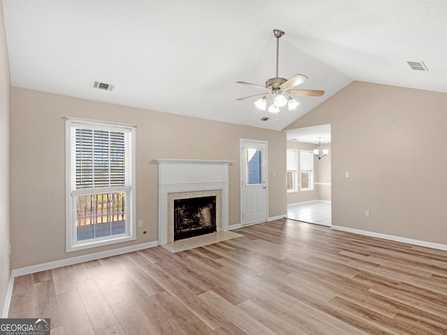 unfurnished living room featuring light wood finished floors, a tiled fireplace, and visible vents