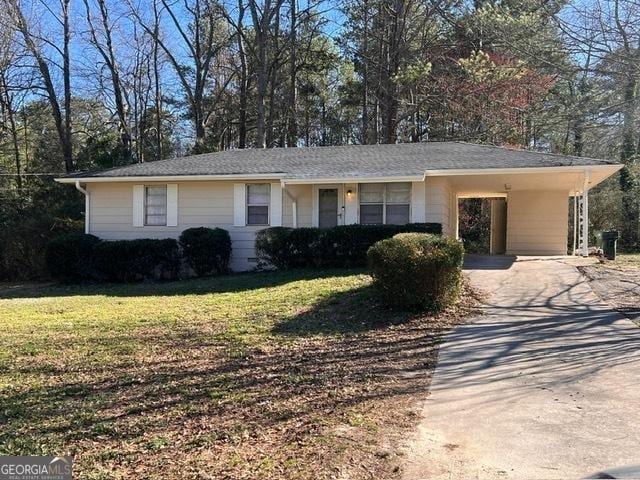 single story home featuring driveway, a carport, and a front yard