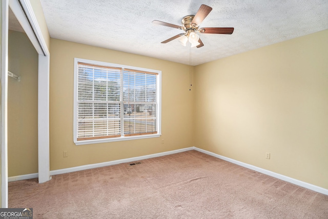 unfurnished bedroom featuring a textured ceiling, visible vents, and carpet flooring