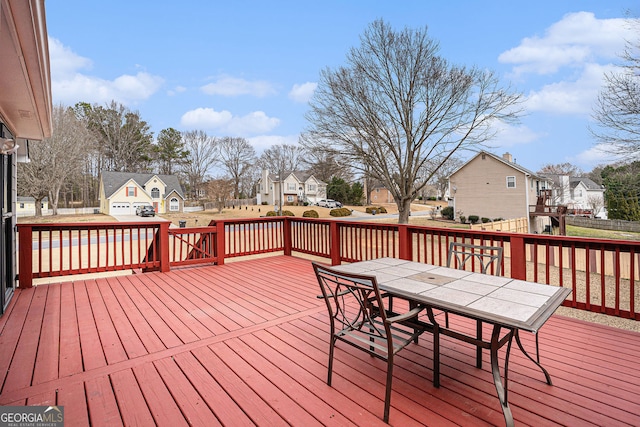 wooden terrace with a residential view and outdoor dining space