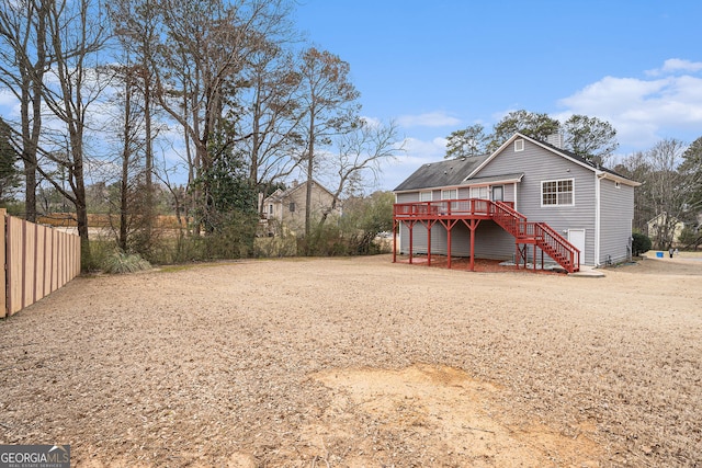 back of house with fence, a deck, and stairs