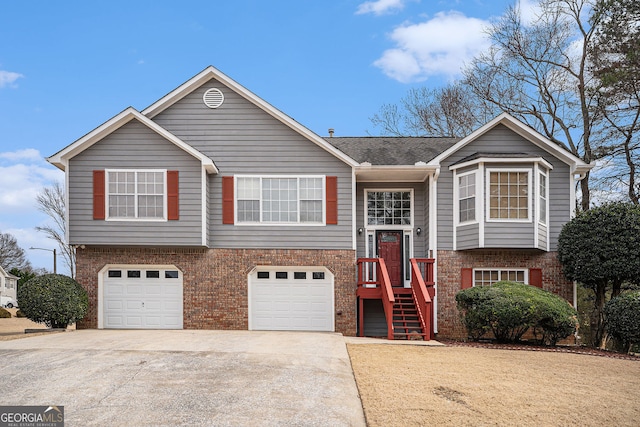 bi-level home with concrete driveway, brick siding, and an attached garage