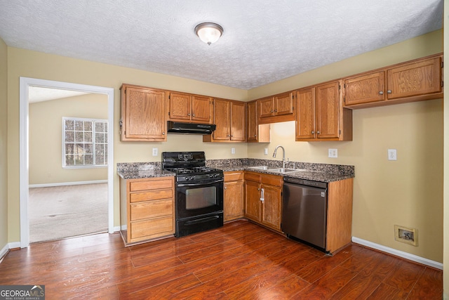 kitchen with a sink, dishwasher, baseboards, under cabinet range hood, and black gas range