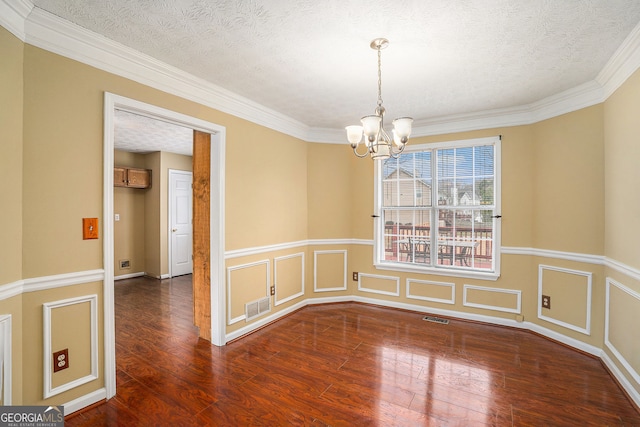spare room with wood finished floors, visible vents, a textured ceiling, and a chandelier