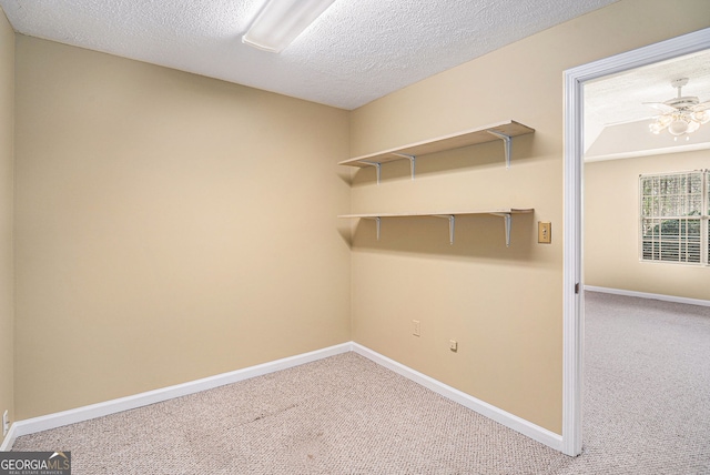 laundry room featuring carpet floors, a textured ceiling, baseboards, and ceiling fan