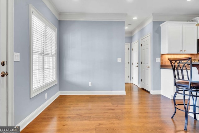 foyer with recessed lighting, crown molding, light wood-style flooring, and baseboards