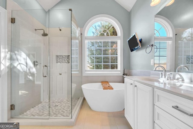 full bathroom with a freestanding bath, a stall shower, vaulted ceiling, and vanity