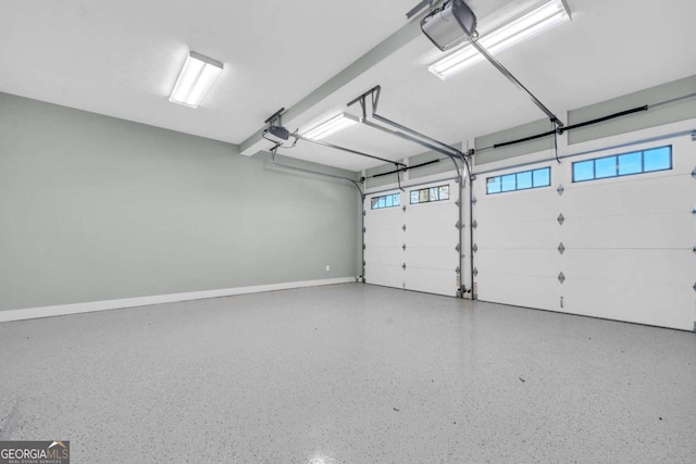 garage featuring a garage door opener and baseboards