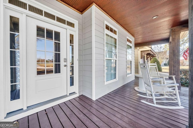 wooden deck with covered porch and french doors