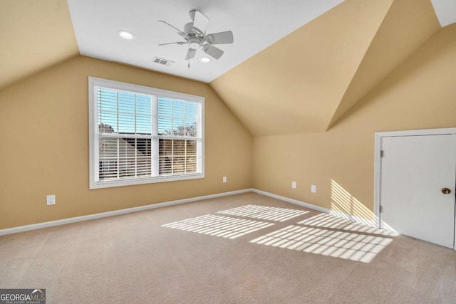 additional living space with vaulted ceiling, carpet, visible vents, and baseboards