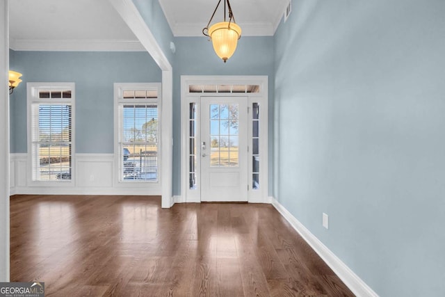 entryway with a healthy amount of sunlight, crown molding, visible vents, and wood finished floors