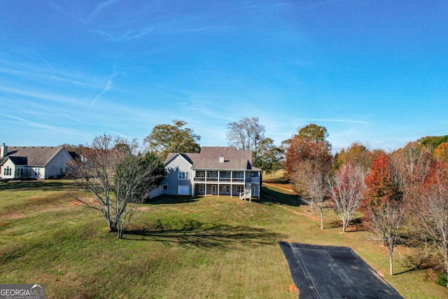 view of front of house with a sunroom and a front yard