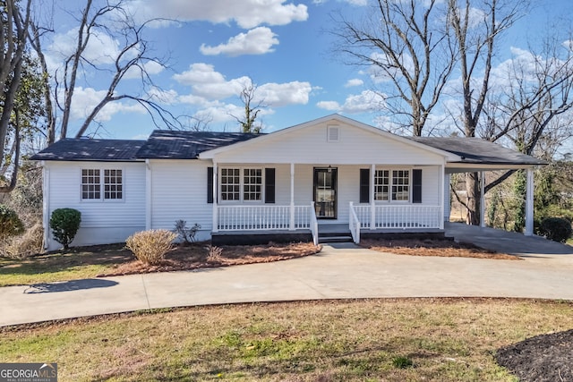 view of front of house featuring driveway, covered porch, and an attached carport