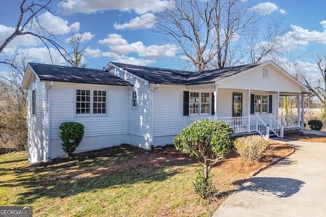 view of front of home with a porch, driveway, and a front lawn