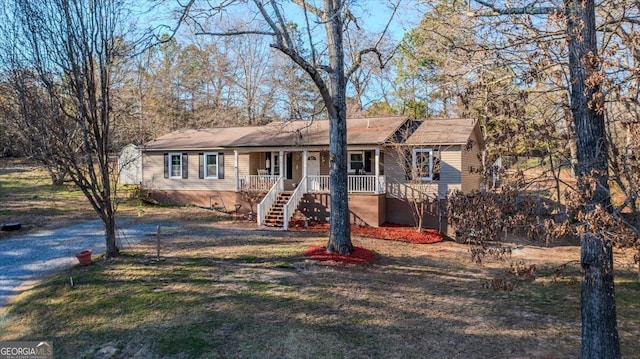 ranch-style house with stairs, a front yard, and covered porch