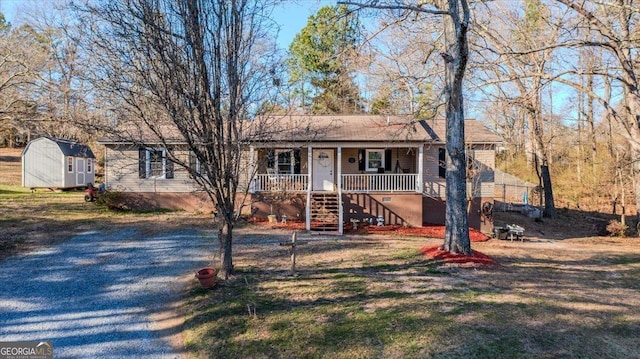 ranch-style house with an outbuilding, a storage shed, covered porch, and stairs