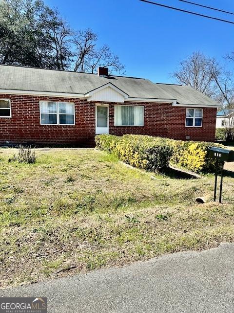 ranch-style house with brick siding and a front yard