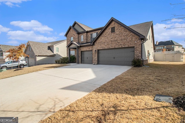 view of front of home featuring brick siding, driveway, and fence