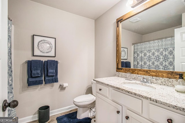 full bathroom featuring toilet, wood finished floors, vanity, visible vents, and baseboards