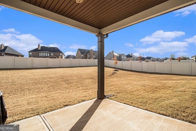 view of yard with a fenced backyard, a residential view, and a patio