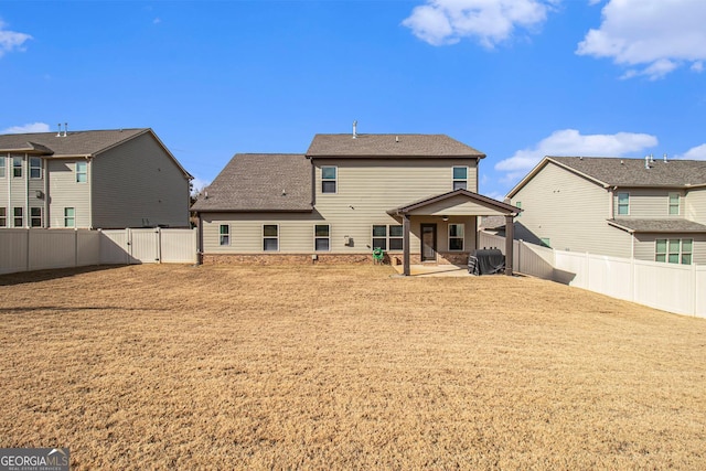 rear view of property with a gate, a patio area, a yard, and a fenced backyard