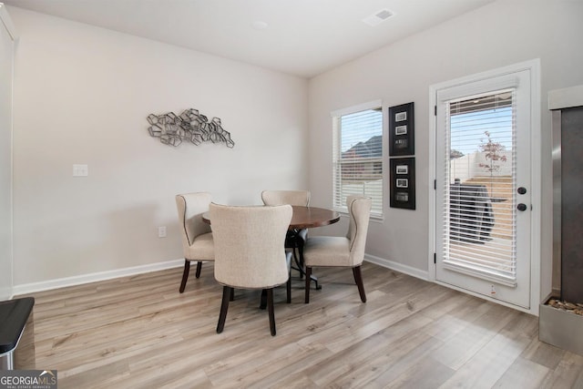 dining room featuring light wood finished floors and baseboards