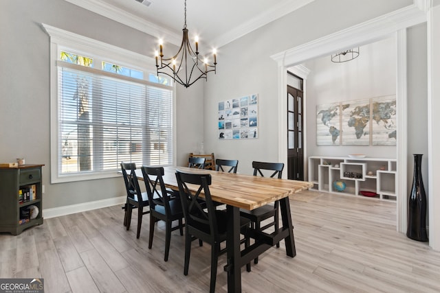 dining space featuring light wood-type flooring, an inviting chandelier, baseboards, and crown molding