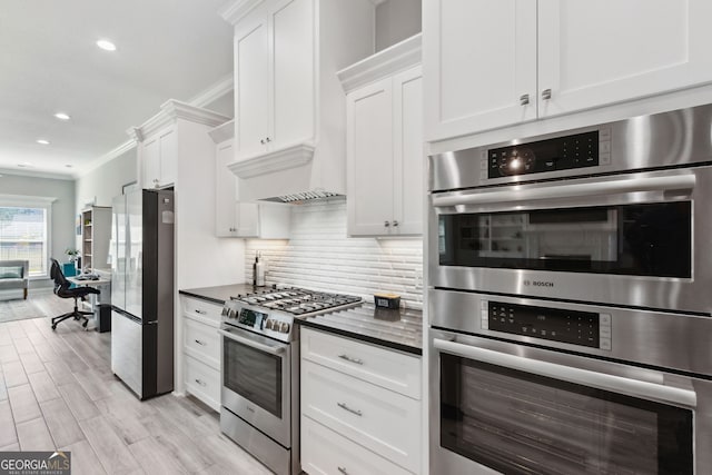 kitchen with tasteful backsplash, dark countertops, ornamental molding, stainless steel appliances, and wood finish floors