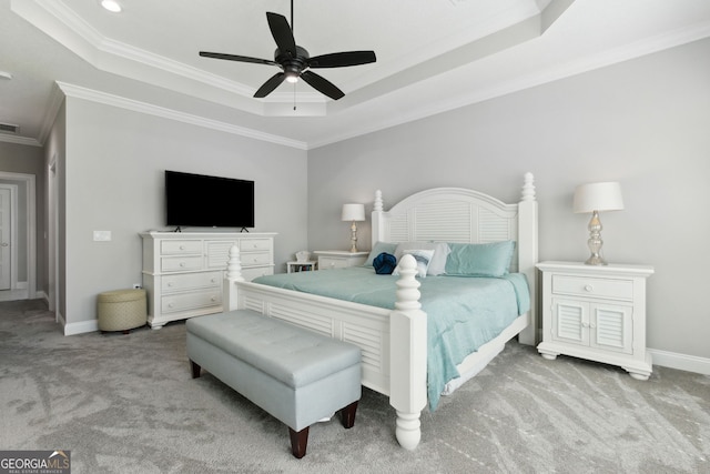 bedroom featuring carpet floors, a raised ceiling, crown molding, and baseboards