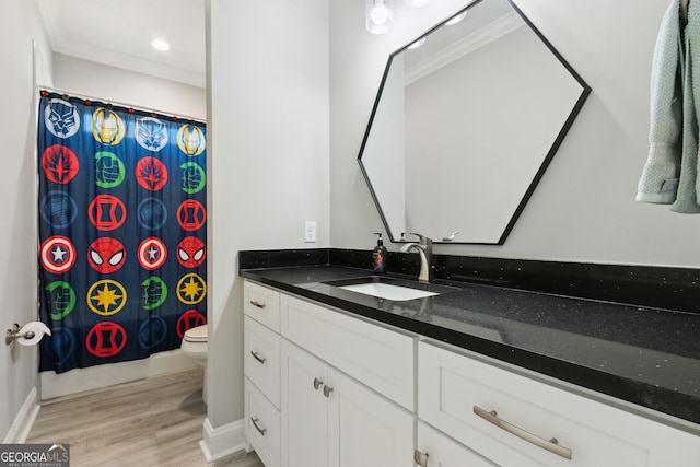 bathroom with toilet, recessed lighting, wood finished floors, vanity, and crown molding