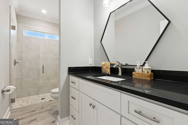 bathroom with crown molding, toilet, a shower stall, vanity, and wood finished floors