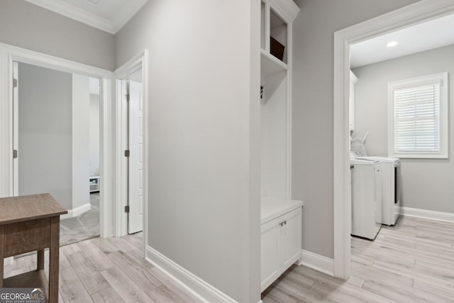 interior space with light wood-type flooring, crown molding, baseboards, and separate washer and dryer