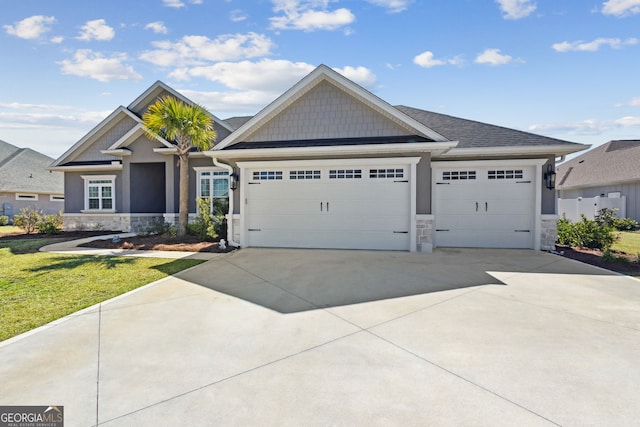 craftsman-style home with stone siding, an attached garage, and driveway