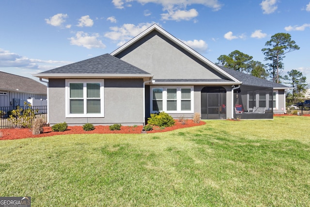 back of property with a lawn, a sunroom, roof with shingles, fence, and stucco siding