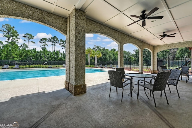 view of patio / terrace with ceiling fan, a community pool, and fence