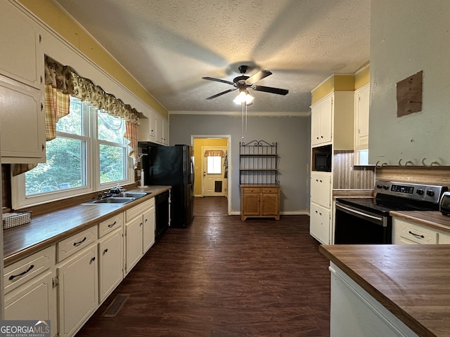 kitchen featuring black appliances, dark wood finished floors, wood counters, and white cabinetry