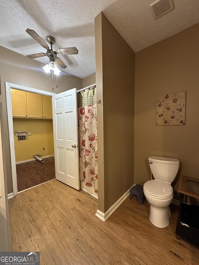 full bath with toilet, ceiling fan, wood finished floors, and visible vents