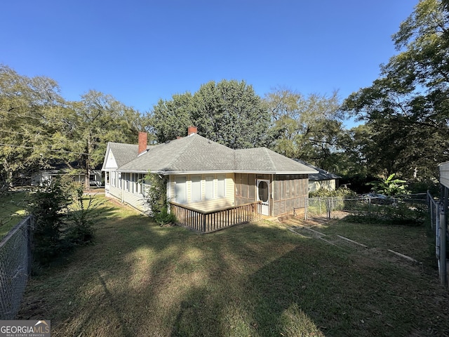 view of side of home featuring a shingled roof, a chimney, fence, and a lawn