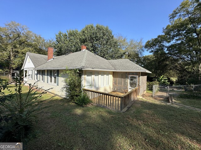 3 Elm St, Porterdale, GA 30014 - back of house featuring a sunroom, a chimney, a shingled roof, and a gate