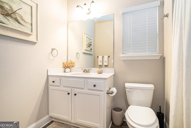 full bath with vanity, toilet, and baseboards