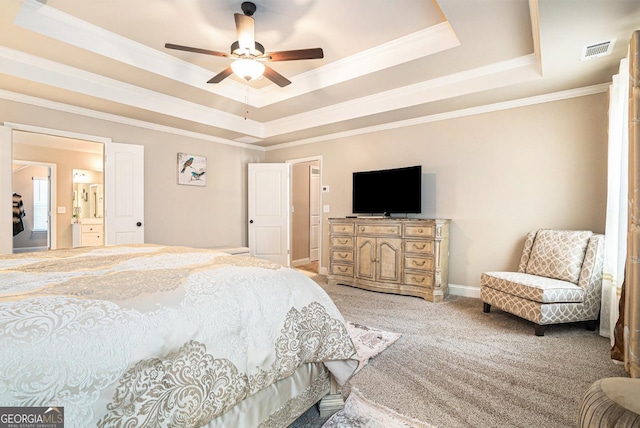 bedroom with a raised ceiling, light colored carpet, visible vents, ornamental molding, and baseboards