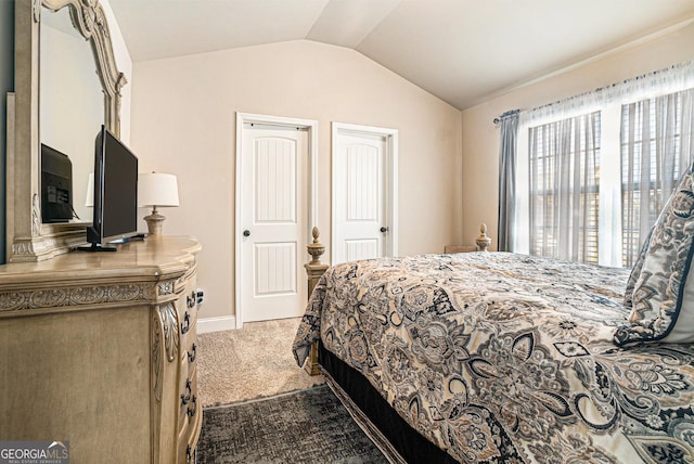 carpeted bedroom with lofted ceiling and baseboards