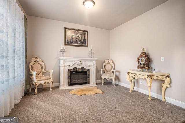 sitting room with carpet flooring, a tile fireplace, and baseboards