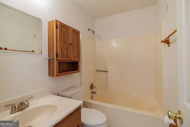 full bathroom featuring toilet, bathing tub / shower combination, a textured ceiling, and vanity