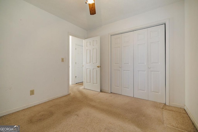 unfurnished bedroom with a closet, carpet flooring, ceiling fan, and baseboards