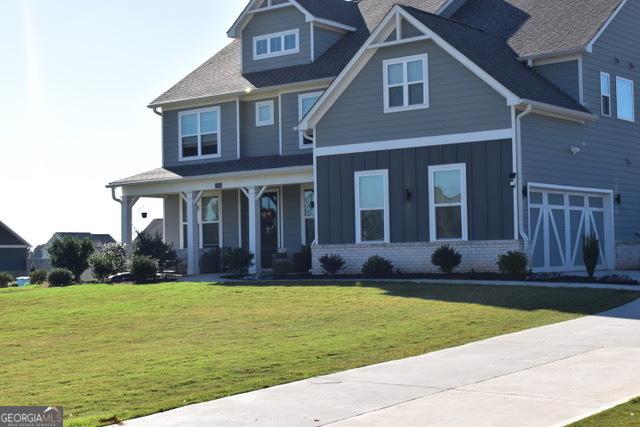 craftsman-style home featuring brick siding, board and batten siding, and a front yard