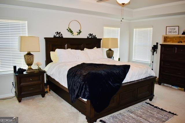 bedroom featuring light carpet, multiple windows, and crown molding