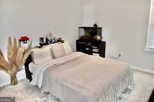 carpeted bedroom featuring baseboards