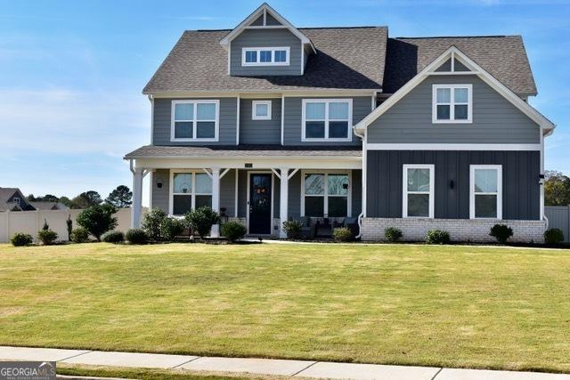 craftsman-style house with brick siding, board and batten siding, and a front yard